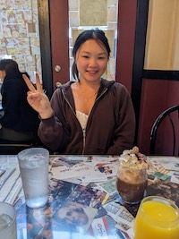 Maggie doing a peace sign at a brunch place.