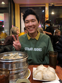 Peter doing a peace sign behind some dumplings.